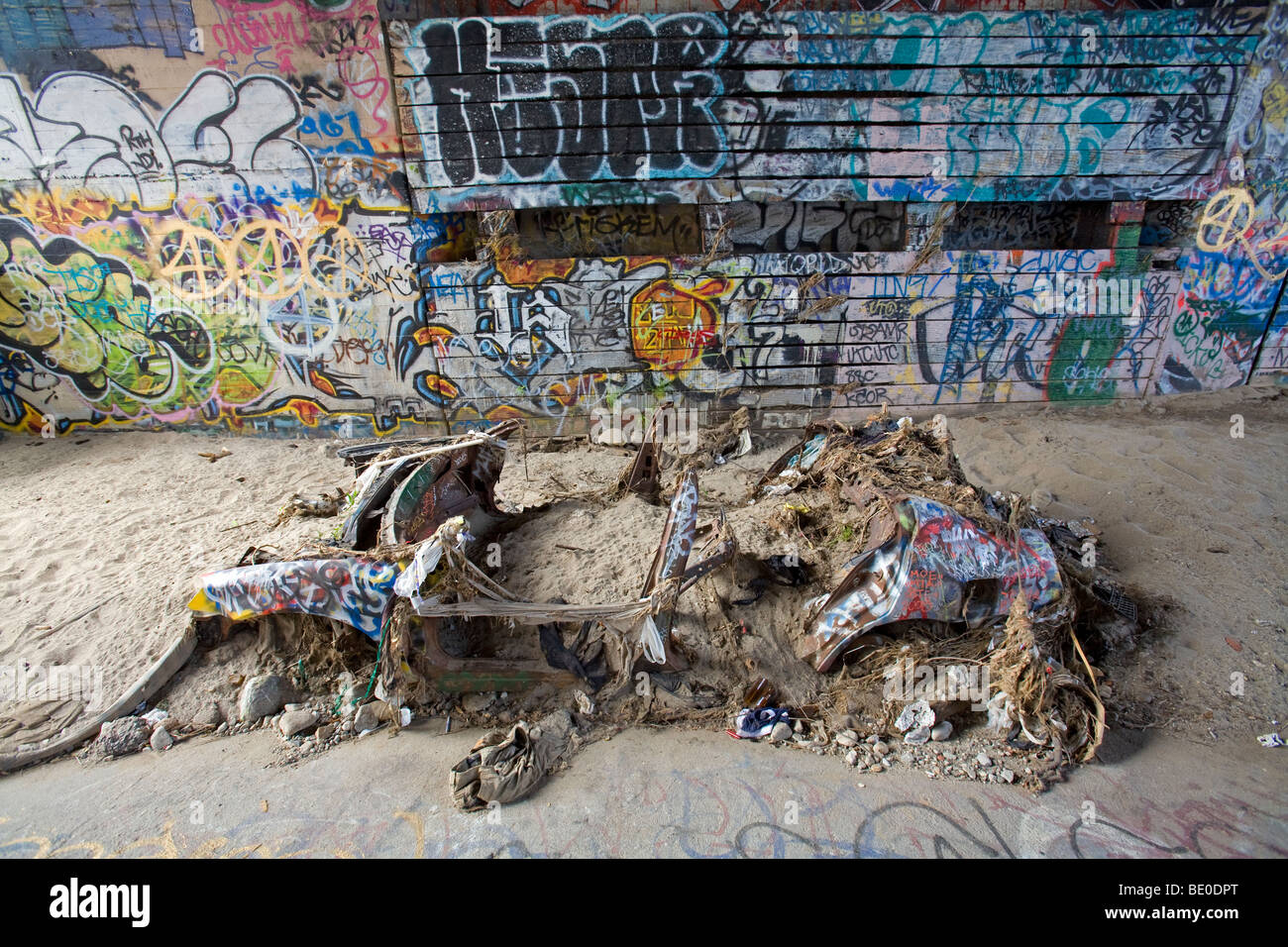 Verlassenes Auto und Graffiti unter Brücke in Los Angeles River, Kalifornien, USA. Stockfoto