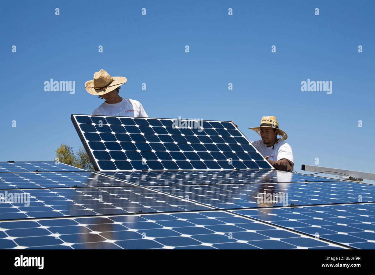 Grüne Arbeiter installieren ein Wohn Raster gebunden Solaranlage auf einem Hügel in Malibu, Kalifornien, USA Stockfoto