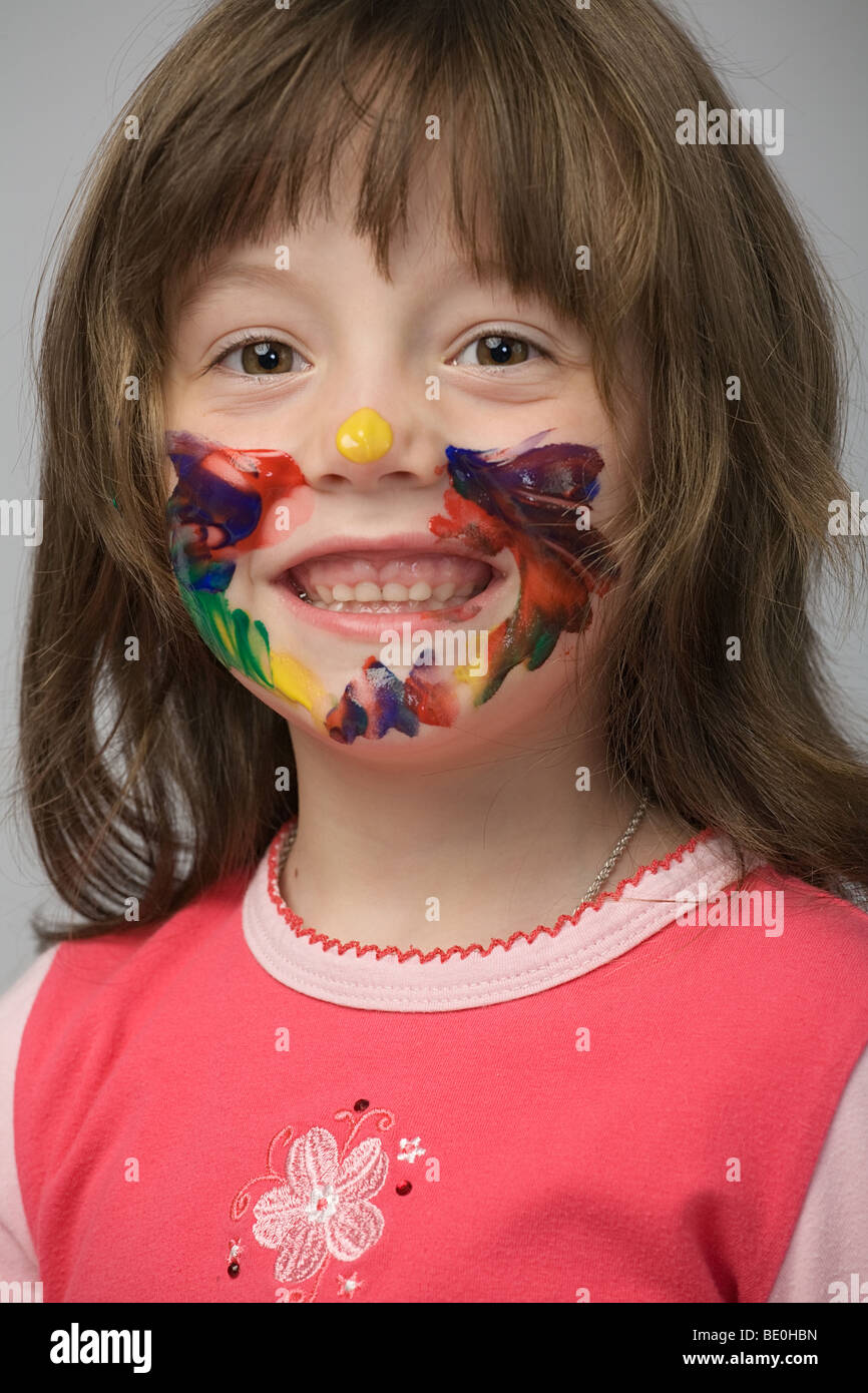 kleines Mädchen mit Gesicht mit Farbe befleckt Stockfoto