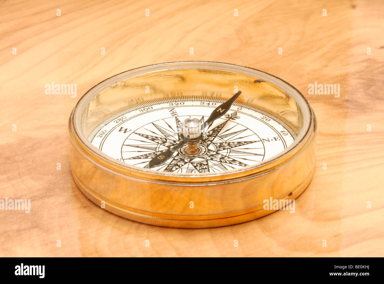 Goldene Kompass am Schreibtisch aus Holz Stockfoto