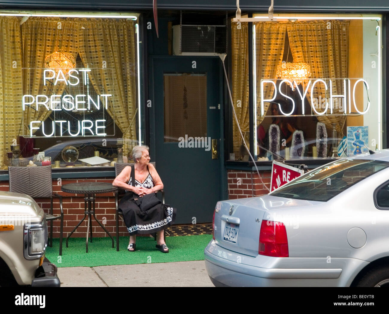 Eine Frau sitzt vor einer psychischen Geschäft in Greenwich Village in New York City, USA Stockfoto