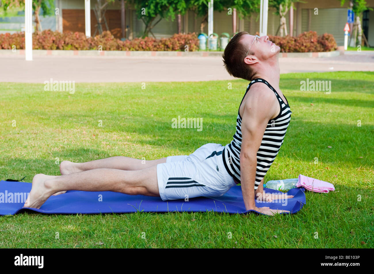 Mann tut Yoga im Freien im Park Stockfoto