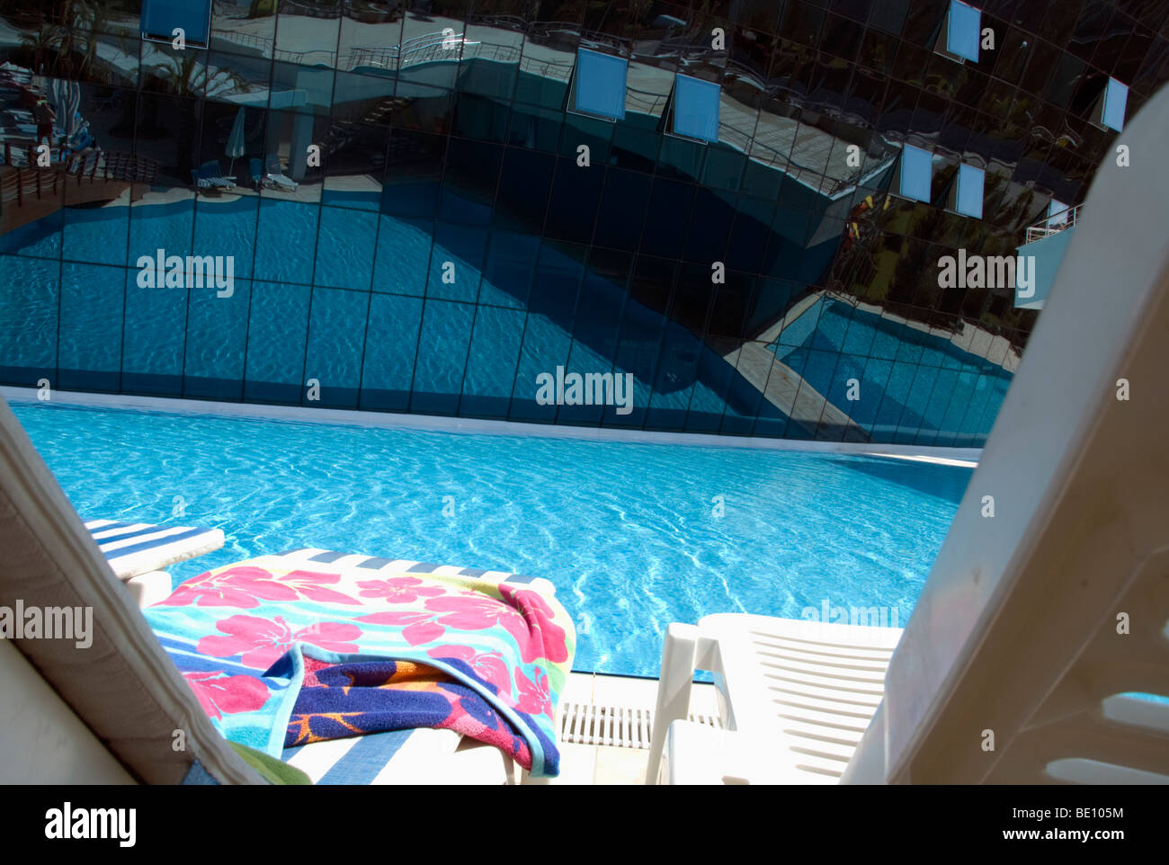 Sommerurlaub - Liegestühle und Handtücher auf der Seite ein Pool Konzeptbild Stockfoto