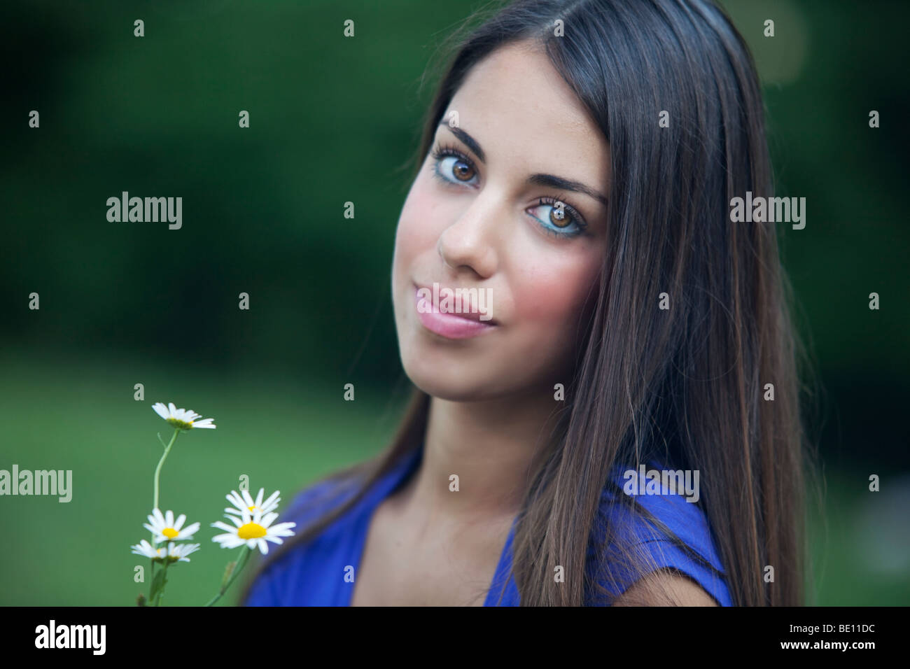 Schöne junge Frau mit Daisy Bouquet und unscharfen Hintergrund Stockfoto