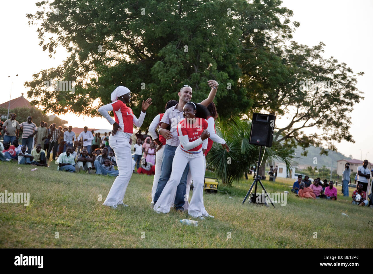 Eine Gruppe von Tänzern in einem Park in Abuja, Nigeria einen Mann umgeben und mit ihm zu tanzen beginnen. Stockfoto