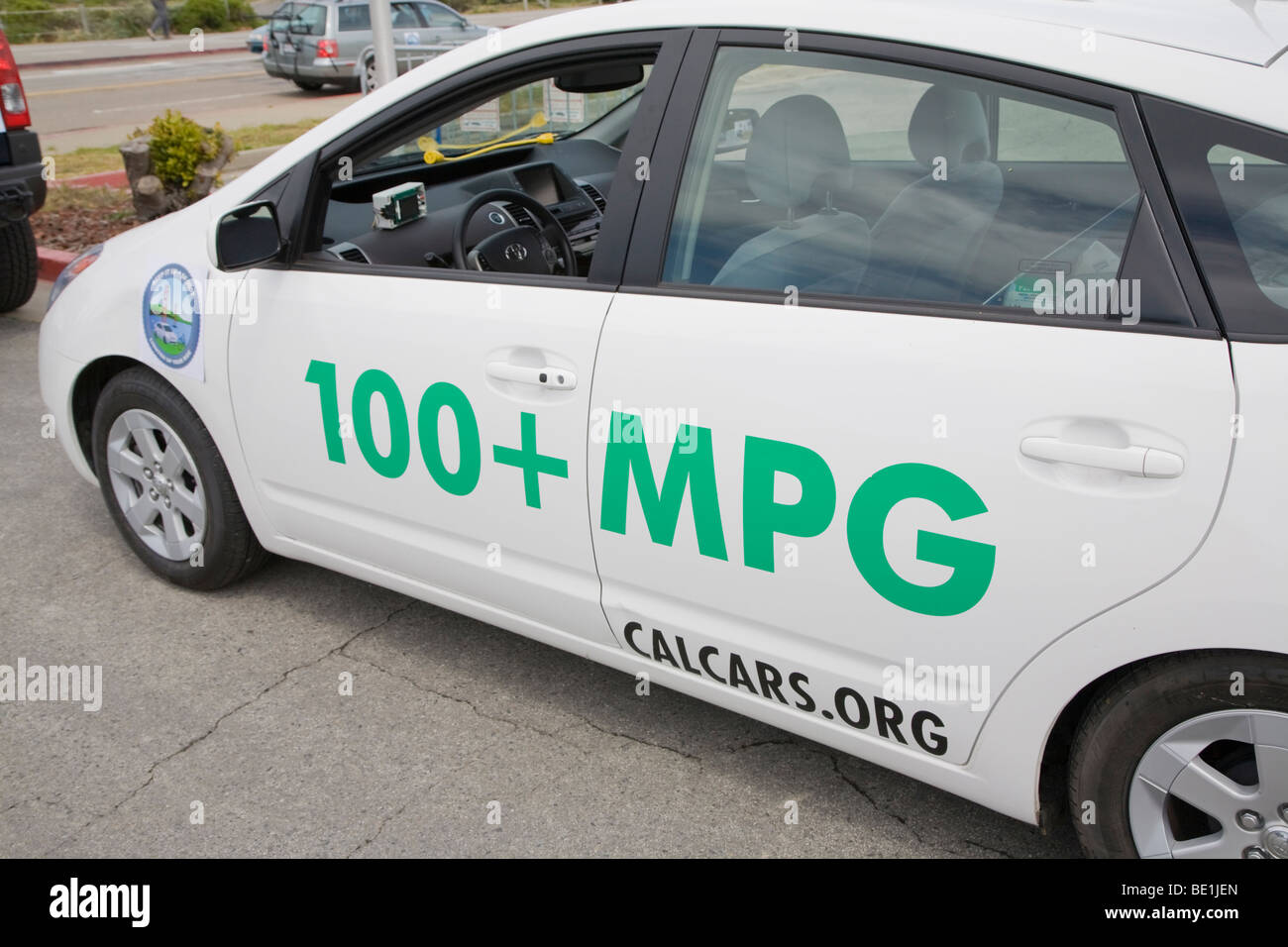 Seitenansicht eines Plug-in Hybrid Toyota Prius Autos mit Aufklebern, die Förderung von 100 Meilen pro Gallone (MPG) und CalCars.Org. Stockfoto