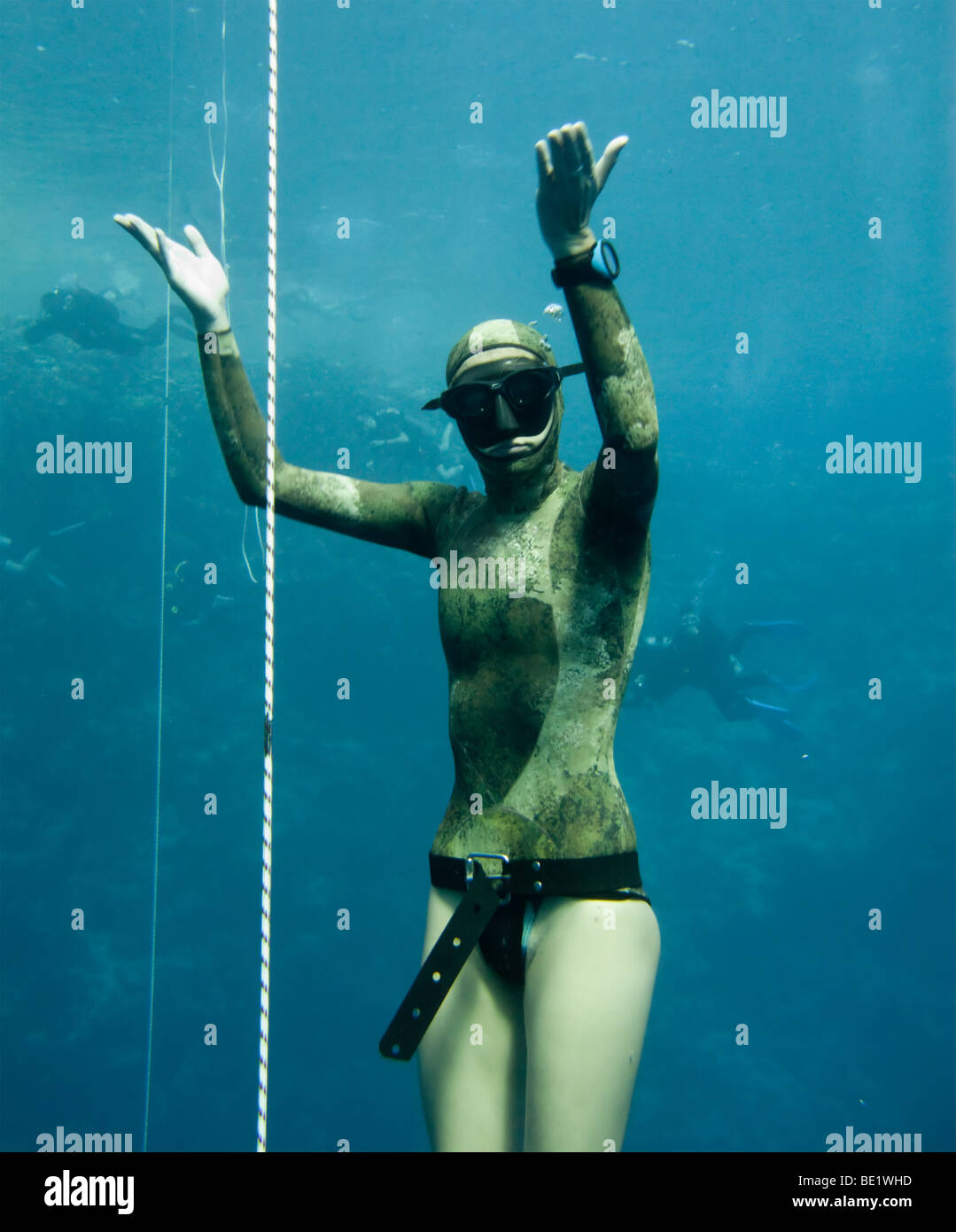 Die Freitaucher steht in der Tiefe des Blue Hole, Dahab, während einige Taucher ihn beobachtest. Stockfoto