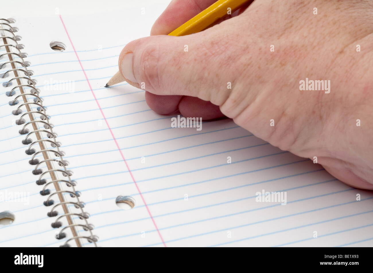 Eine männliche Hand bereit, mit einem Bleistift auf gefütterte Briefpapier schreiben Stockfoto