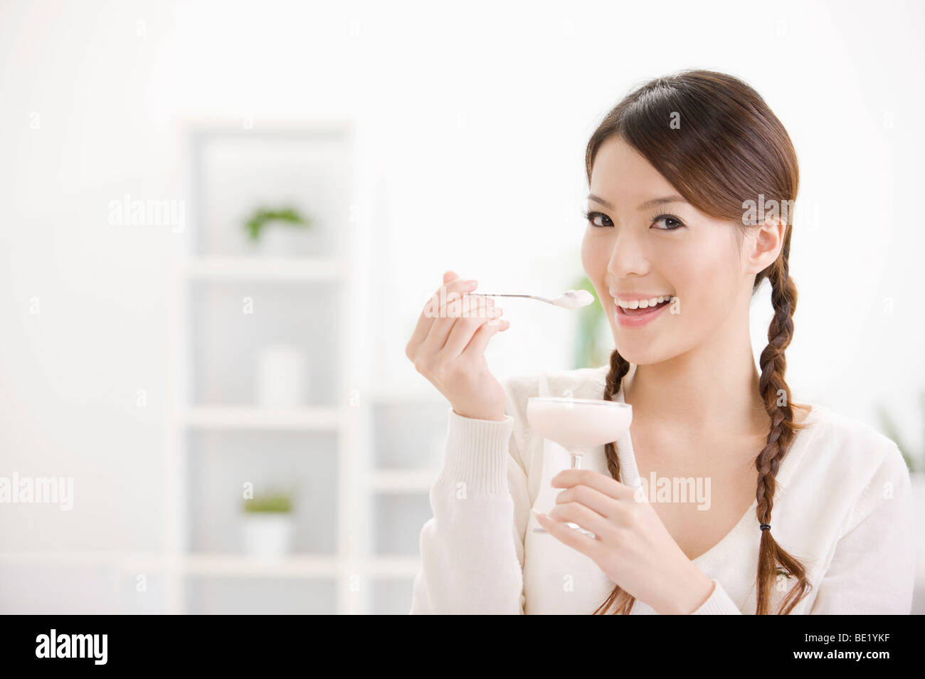 Junge Frau hält einen Cupcake, Porträt Stockfoto