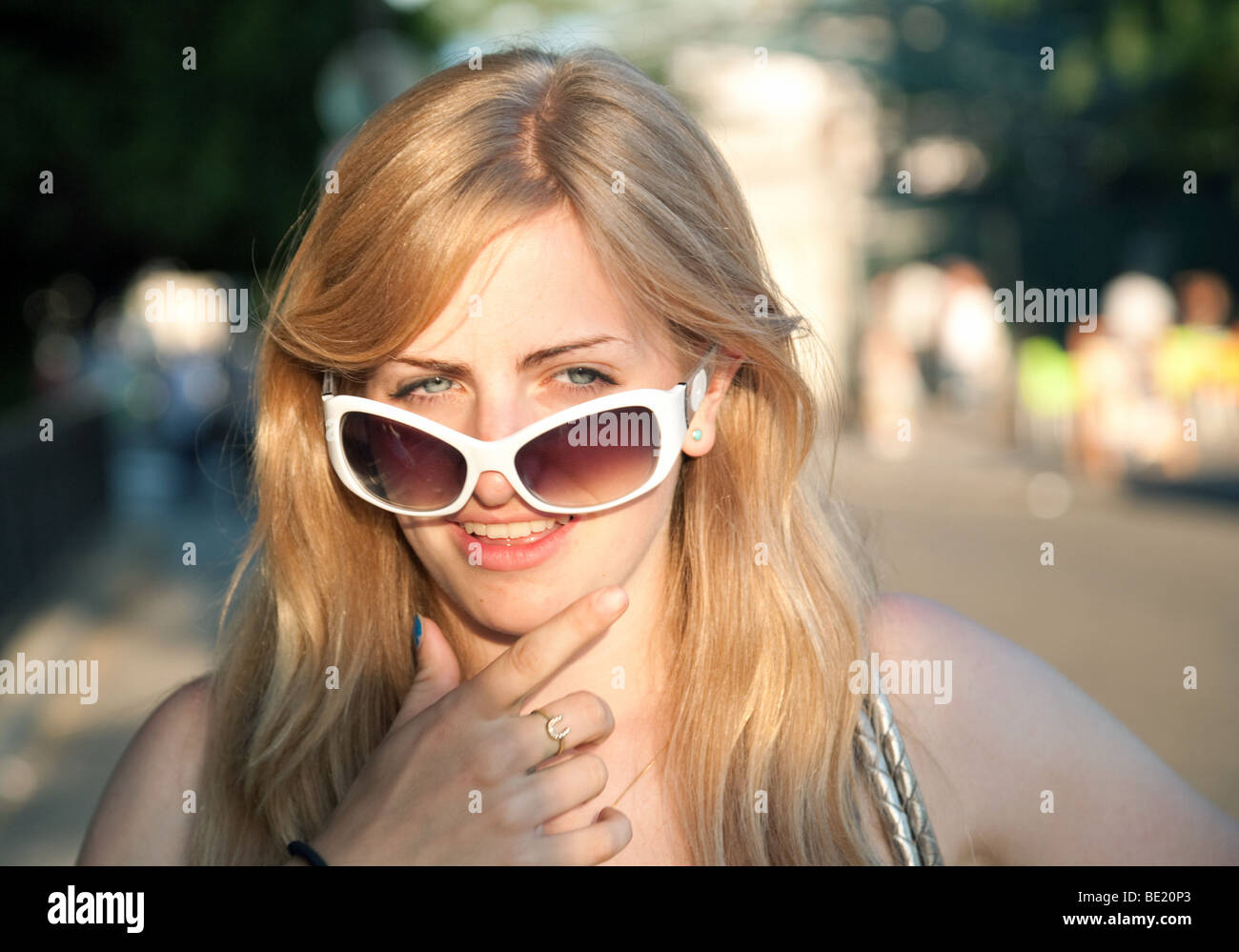 Kopf und Schultern portrait einer attraktiven Blondine kaukasischen Teenager im Alter von 18 Jahren Suche über Sonnenbrillen, Großbritannien Stockfoto