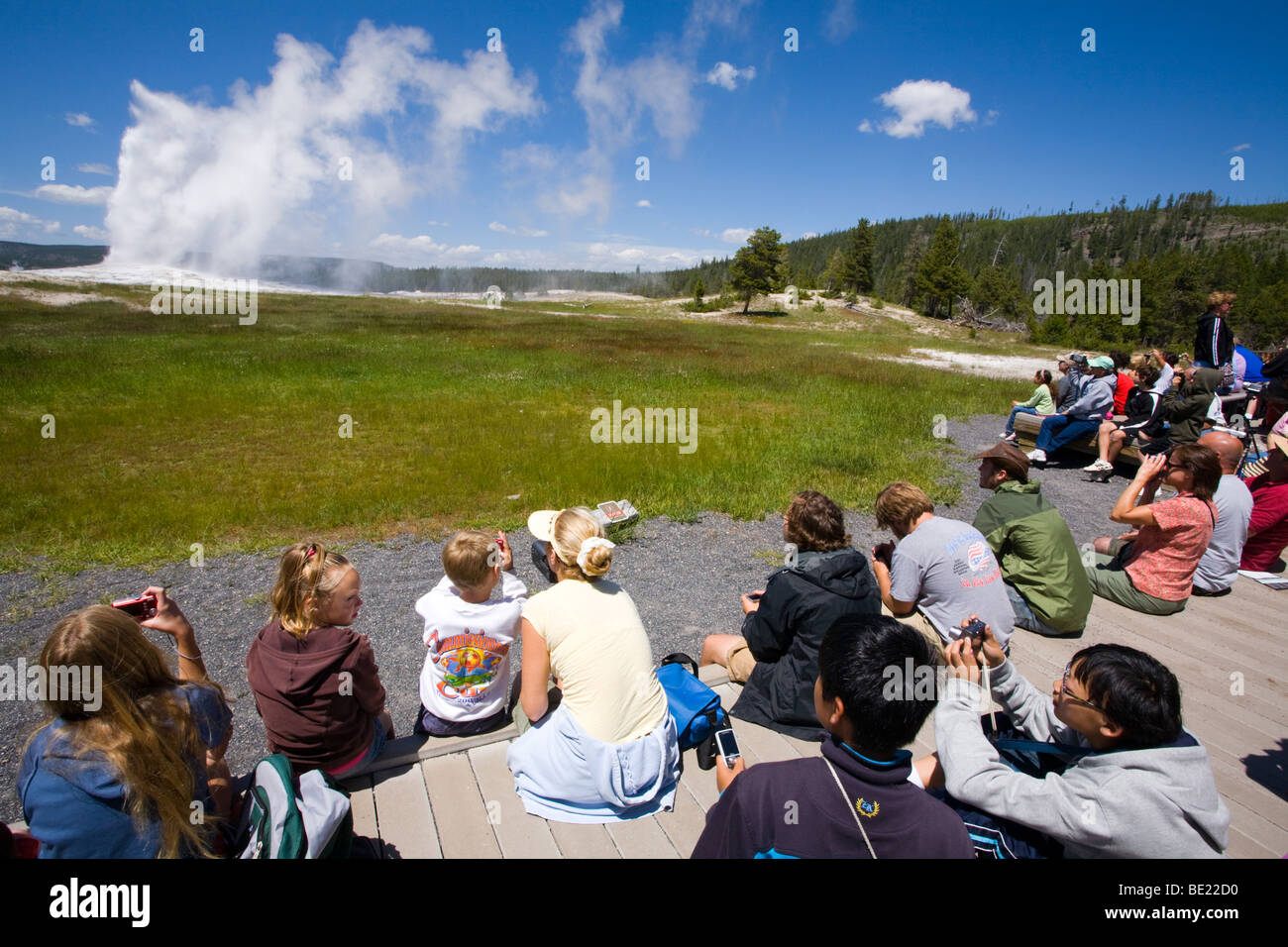 Menschen beobachten Old Faithful Geysir im Yellowstone-Nationalpark, Wyoming Stockfoto