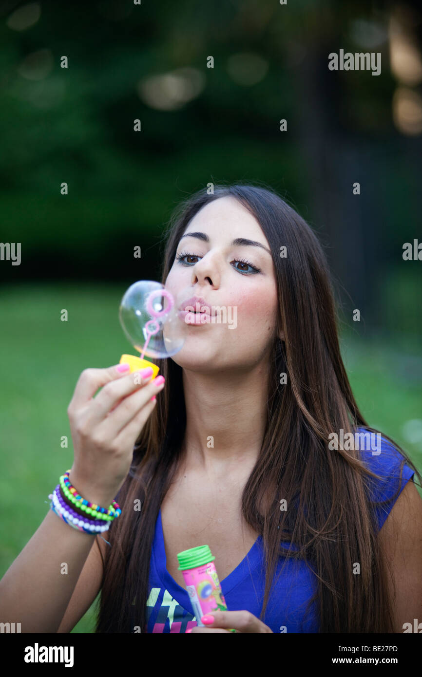 Junge Frau im Garten Seifenblasen in der Luft Stockfoto