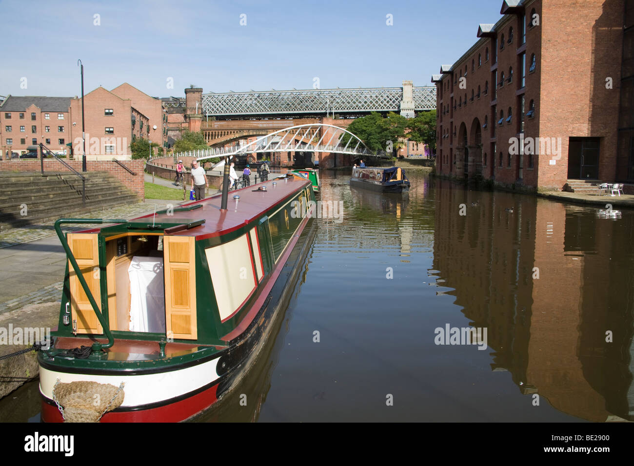 Manchester England UK paar Lenkung ein Narrowboat in Kanal-Becken in der sanierten Castlefields Teil der Stadt Stockfoto