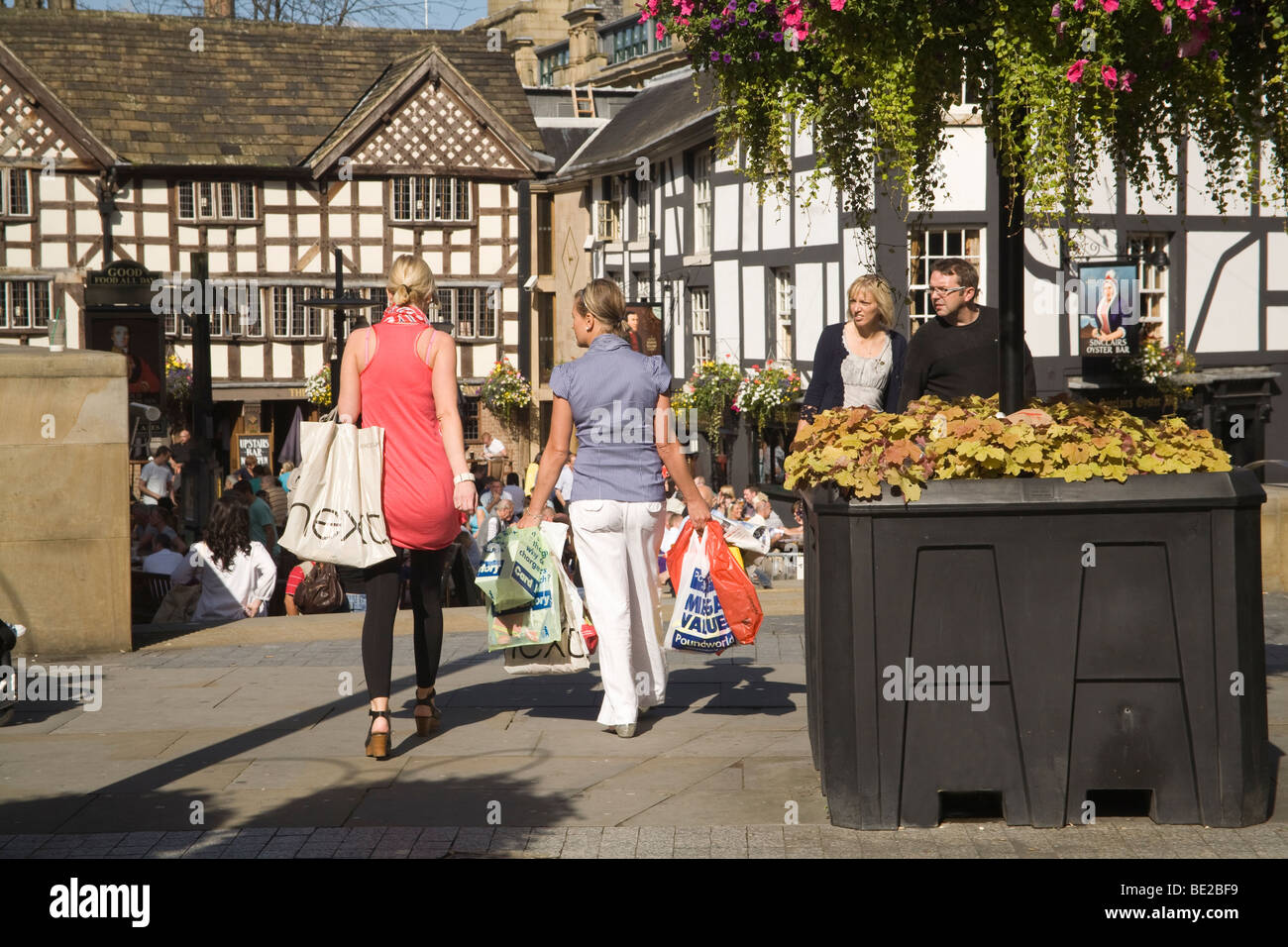 Manchester England UK A paar weibliche Käufer voller Plastiktüten nach einer Sitzung des Retail-Therapie Stockfoto
