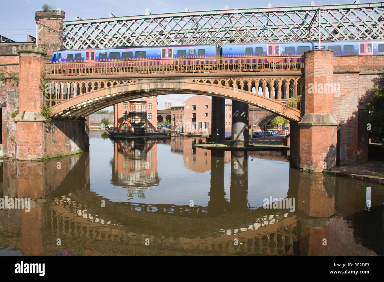 Manchester England UK Zug Überquerung einer Brücke über Riesen Canal Basin im Castlefields Gegend der Stadt historische Schutzgebiet Stockfoto