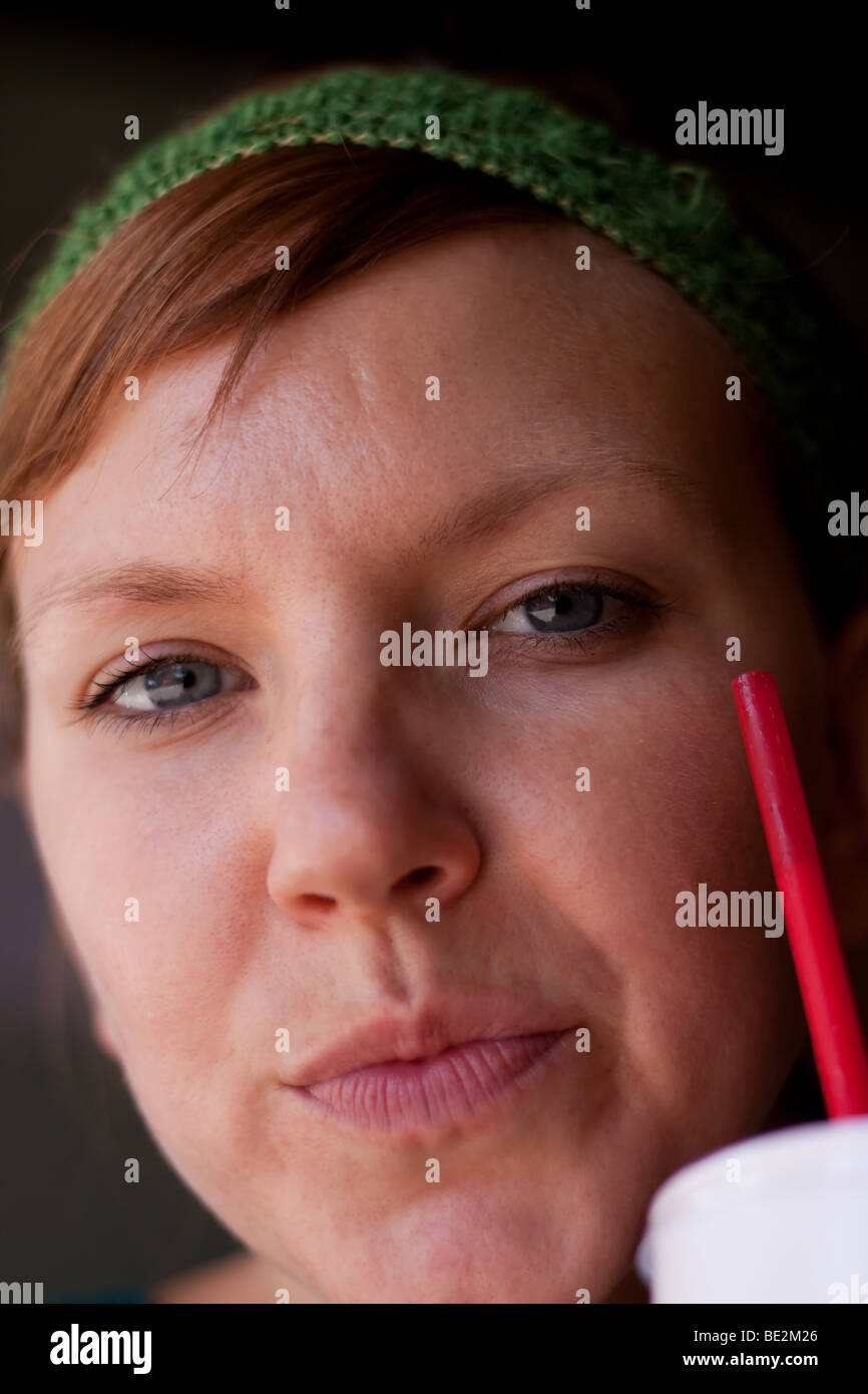 Eine junge Frau aus einem Styroporbecher trinken Stockfoto