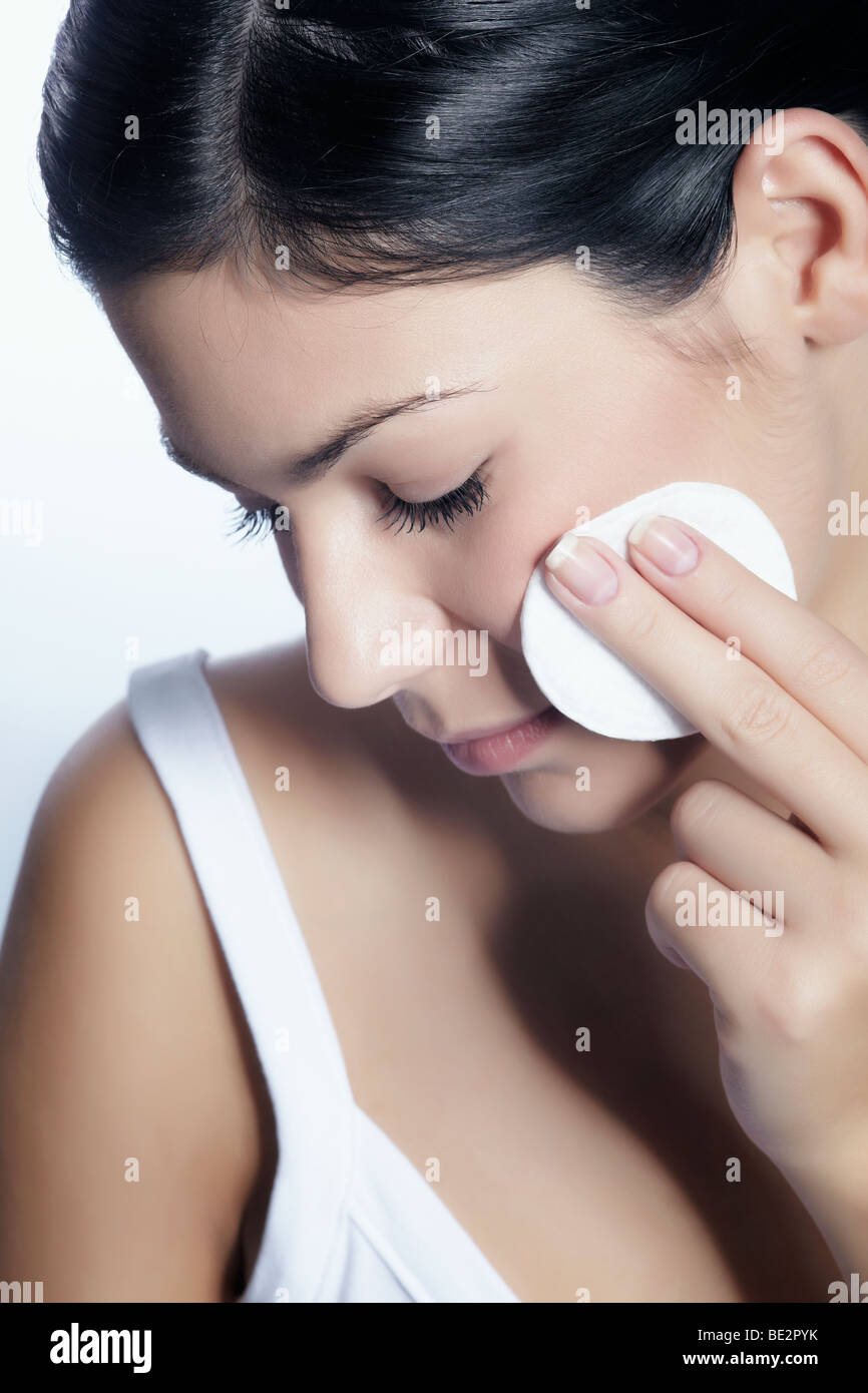 Junge Frau entfernen Make-up mit einem Wattepad, Schönheit Stockfoto