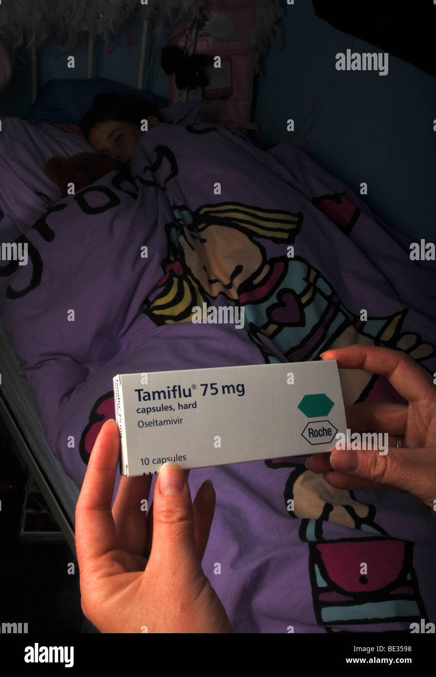 Tamiflu, Kind im Bett der Mutter hält eine Schachtel mit Tamiflu Stockfoto