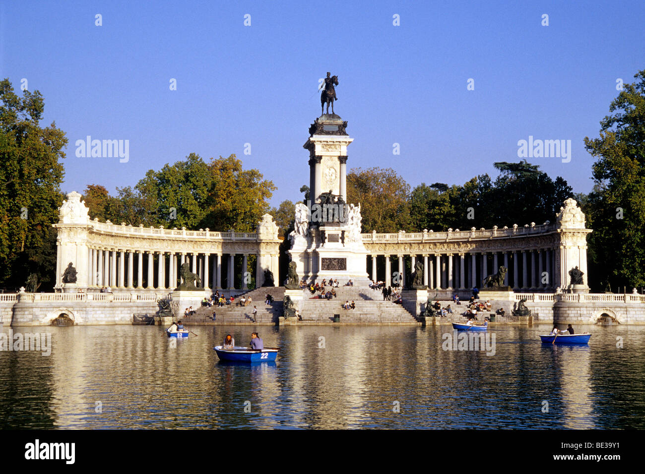 Kolonnade und Reiter Statue des Denkmals von Alfonso XII, Glorieta De La Sardana auf Estanque, Ruderbooten auf dem See in der Stockfoto