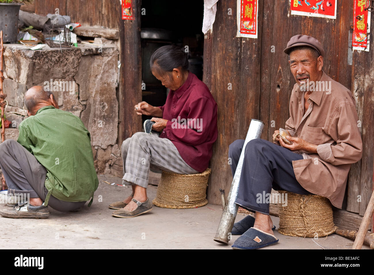 Han-Chinesen werkeln außerhalb ihrer Wohnung in Tonghai, Yunnan, China Stockfoto