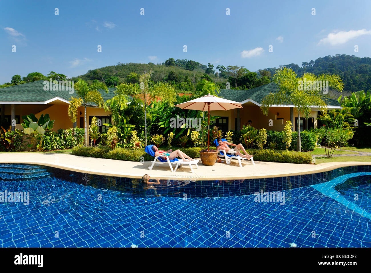 Frau im Liegestuhl am Pool, Bungalows mit grünen, Palm Garden Resort, Khao Lak, Phuket, Thailand, Asien Stockfoto