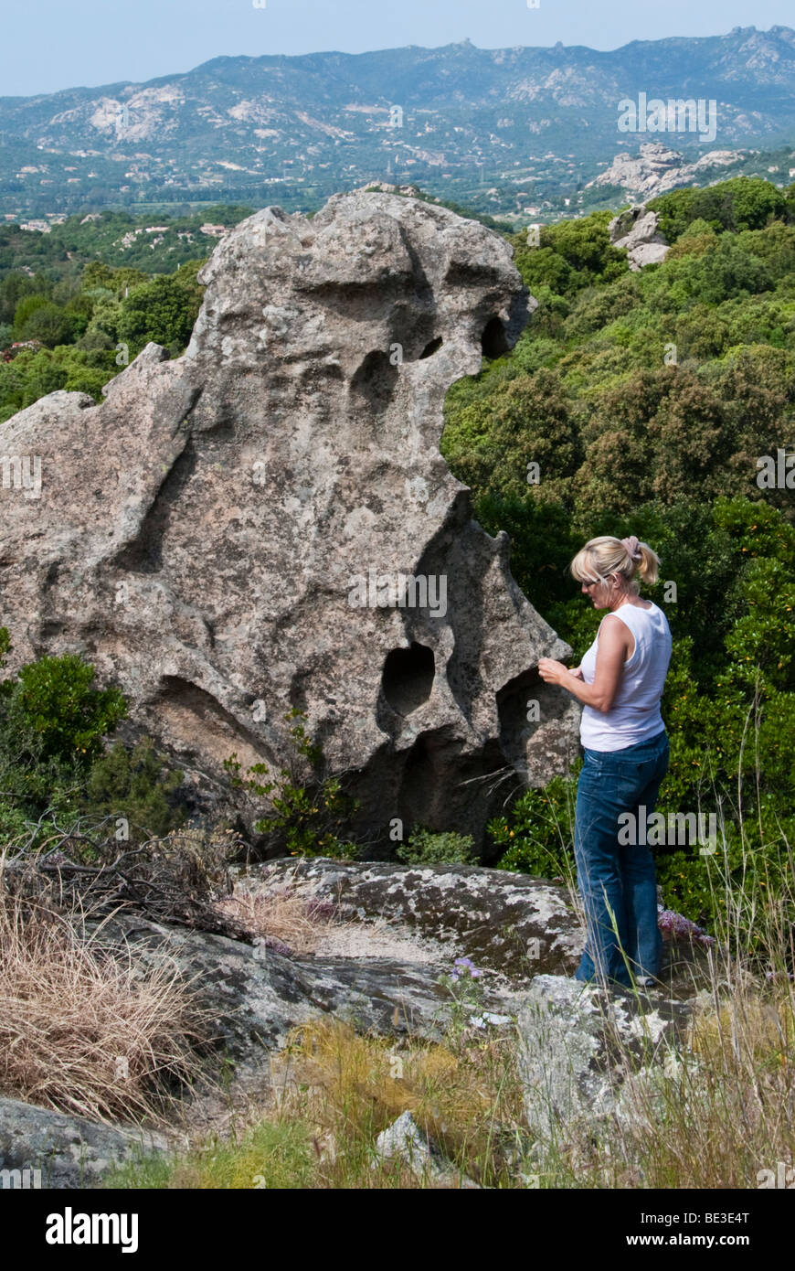Touristen, die mit dem Fotografieren in der Nähe von einem zerklüfteten Felsen in Nord-Sardinien, Italien Stockfoto