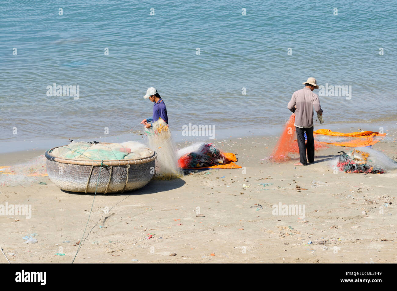 Zwei Fischer am Strand reparieren ihren Fischfang Netze, Mui Ne, Vietnam, Asien Stockfoto