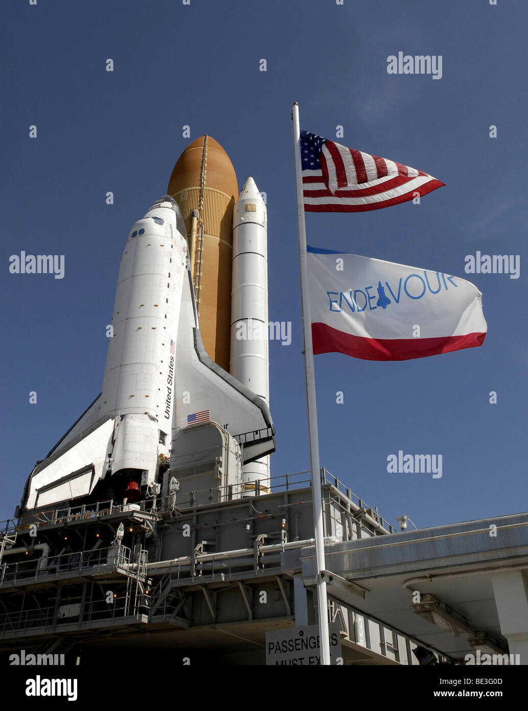 Bei der NASA Kennedy Space Center in Florida schwingen Fahnen im Wind wie Space Shuttle Endeavour Ansätze Startrampe 39A. Stockfoto