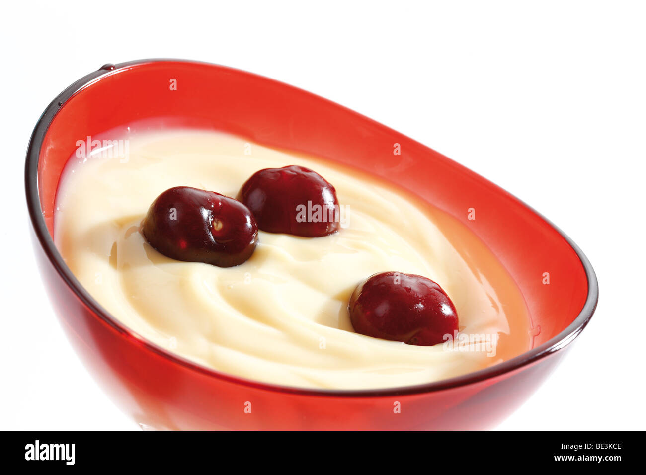 Vanillepudding und Kirschen in eine Glasschüssel Stockfoto