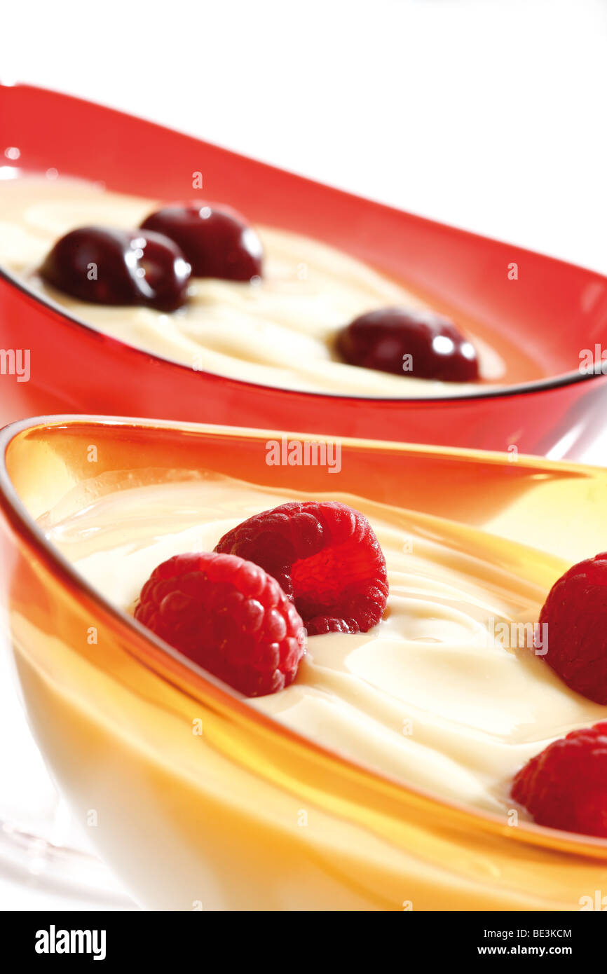 Vanillepudding mit Kirschen und Himbeeren in eine Glasschüssel Stockfoto