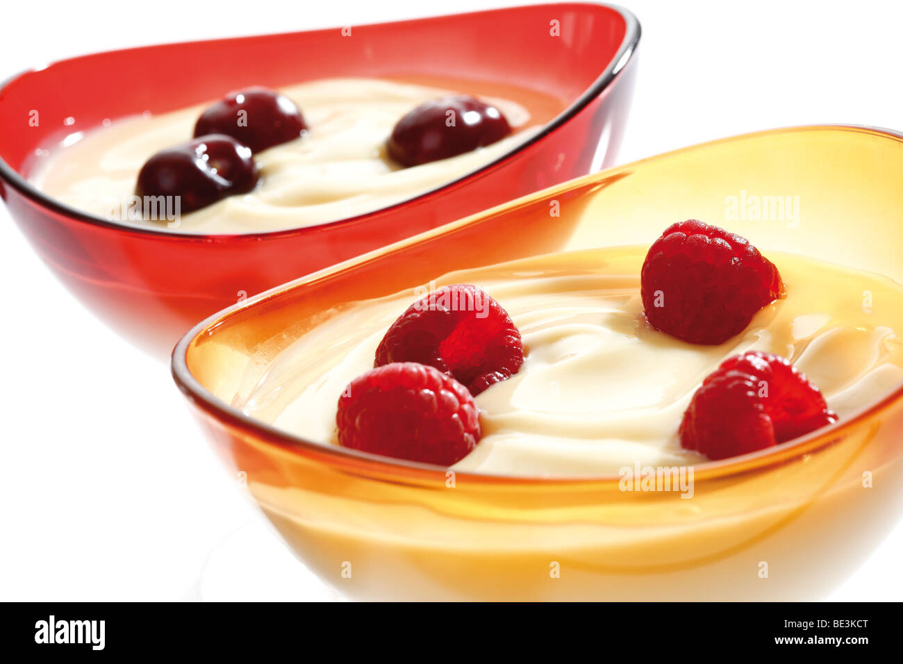 Vanillepudding mit Kirschen und Himbeeren in eine Glasschüssel Stockfoto