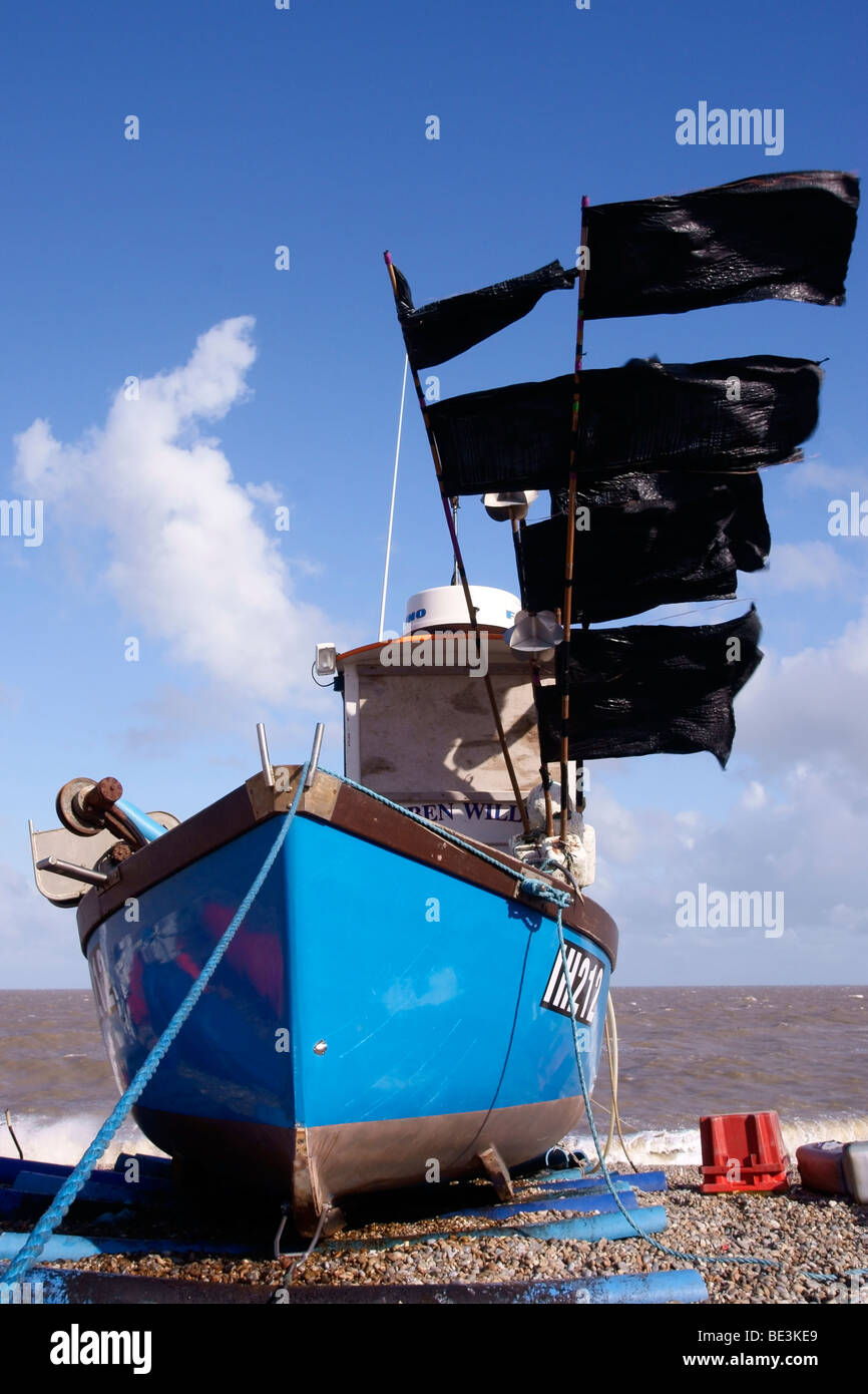 Angelboot/Fischerboot mit Lobster Pot Markierungsfahnen flattern bei starkem Wind am Strand von Aldeburgh Stockfoto