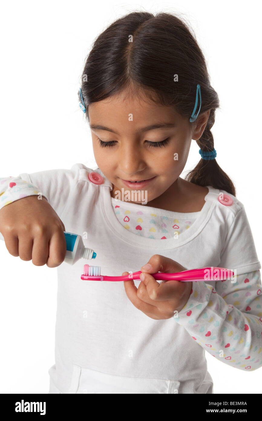 Kleines Mädchen setzt die Zahnpasta auf ihre Zahnbürste Stockfoto