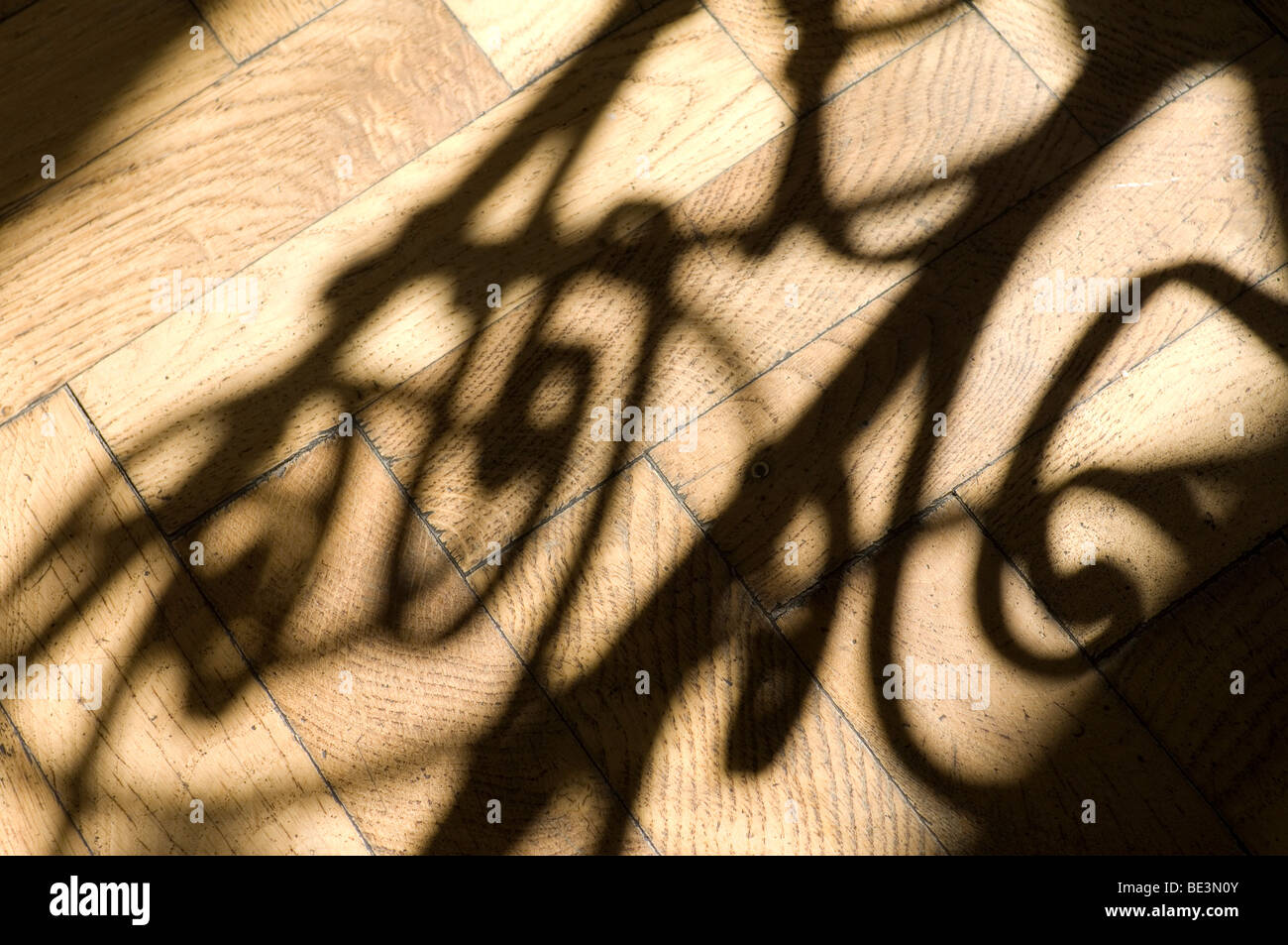 Alte Treppe Geländer Gießen Schatten auf Holzboden Stockfoto