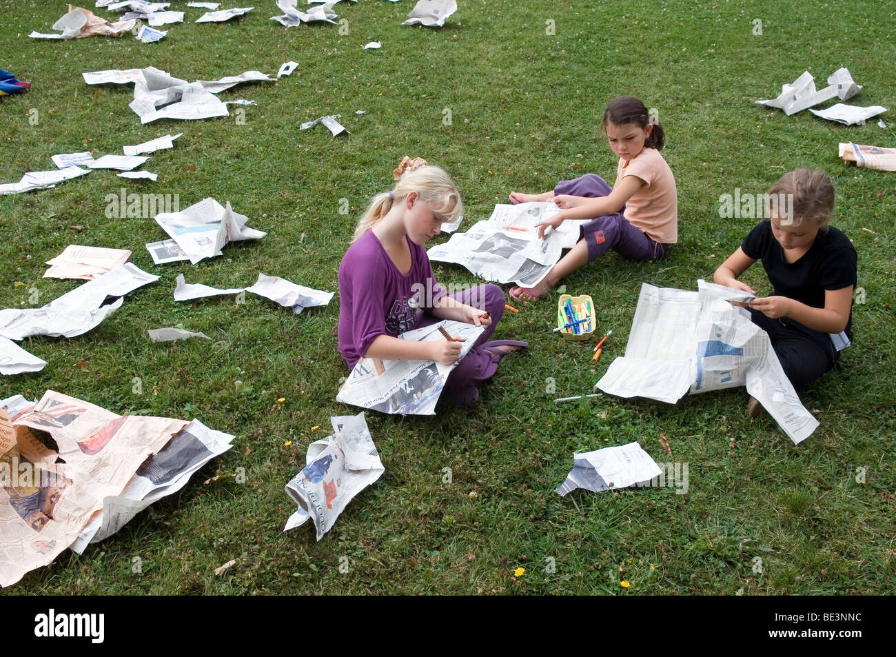 Kinder machen Tücher mit alten Zeitungen Stockfoto