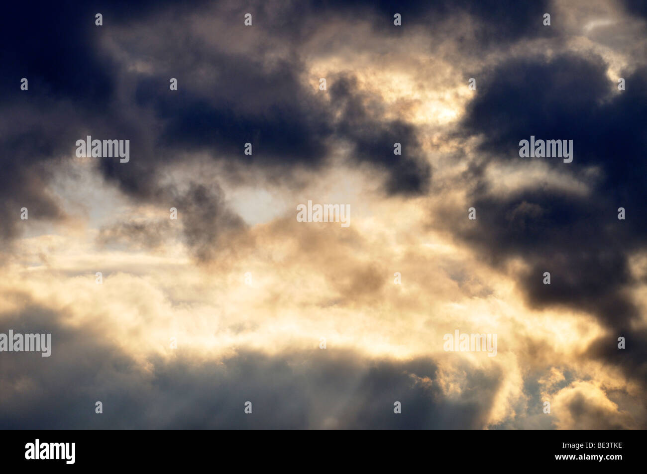 Sonnenstrahlen brechen durch Wolken von Gewitterhimmel. Stockfoto