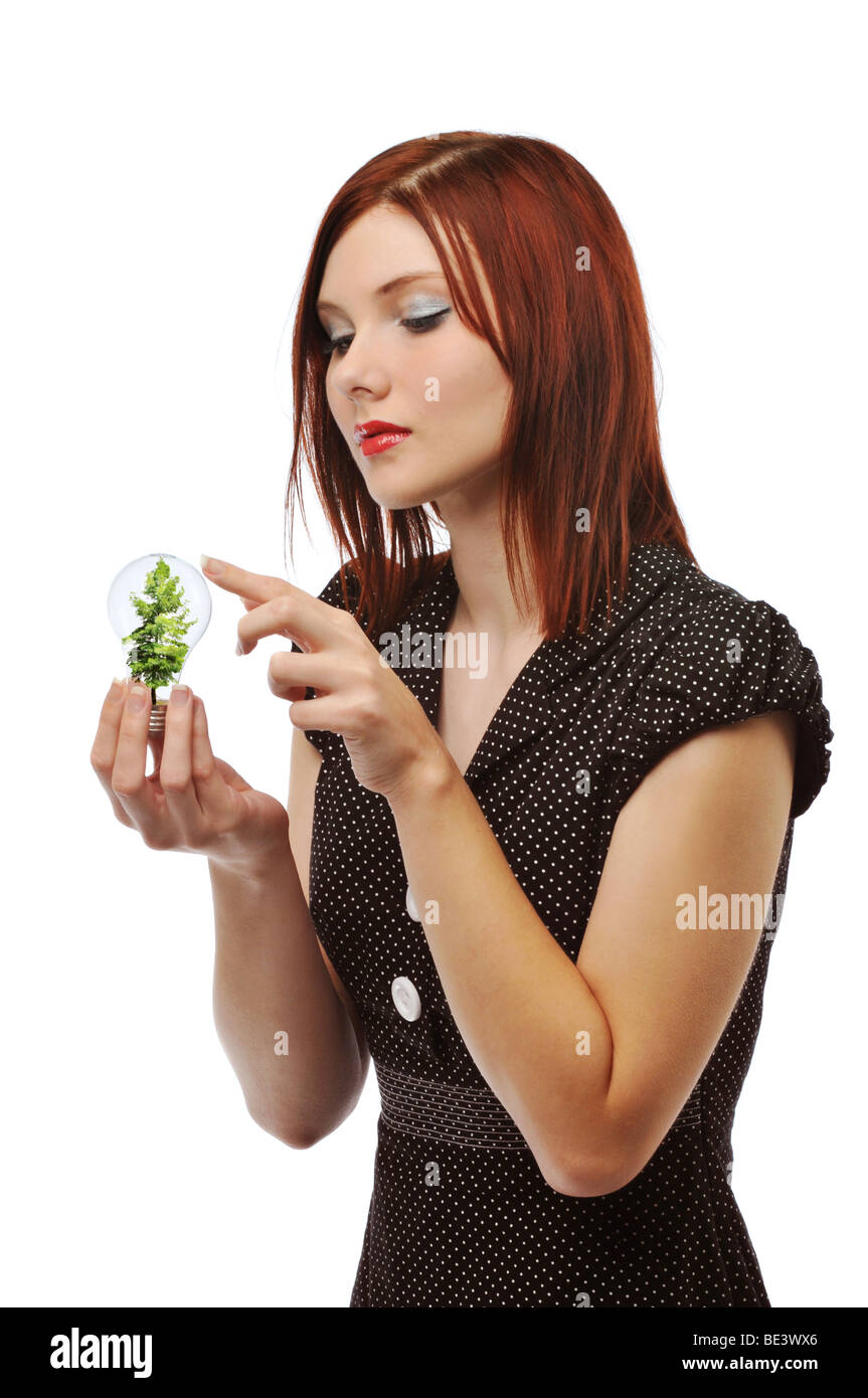 Geschäftsfrau hält eine Glühbirne mit einem Baum, isoliert auf weiss Stockfoto