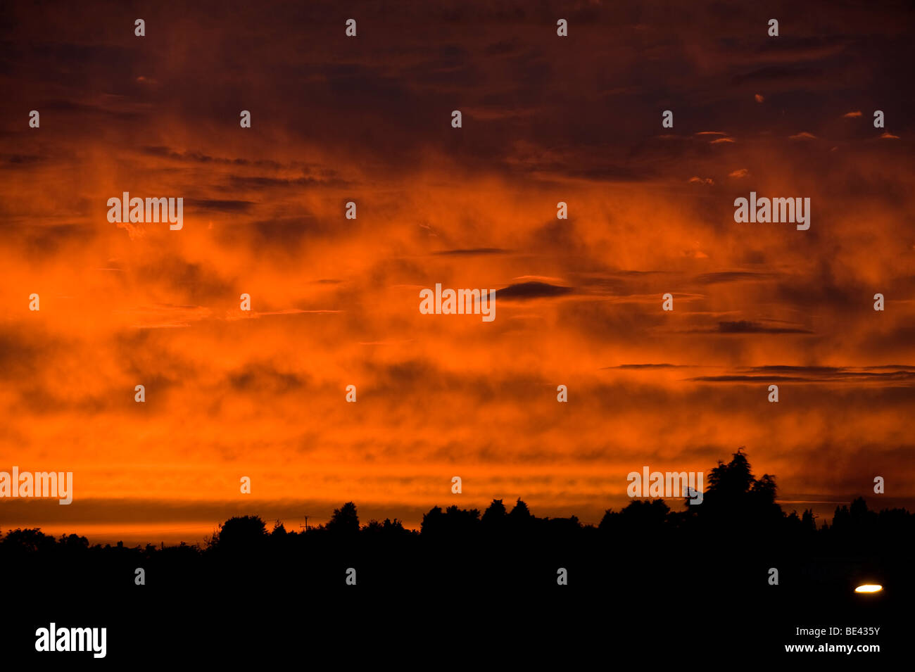 Linsenförmige Wolken im Bild gegen ein tief rot und Orange feurigen Sonnenuntergang Blick fast wie fremde Besucher in den Himmel Stockfoto