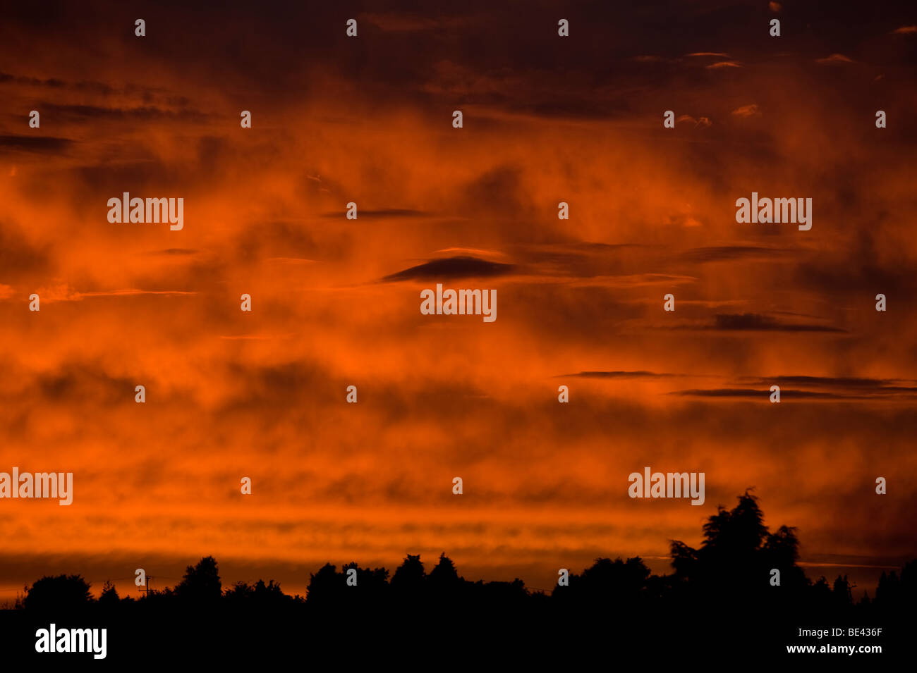Linsenförmige Wolken im Bild gegen ein tief rot und Orange feurigen Sonnenuntergang Blick fast wie fremde Besucher in den Himmel Stockfoto
