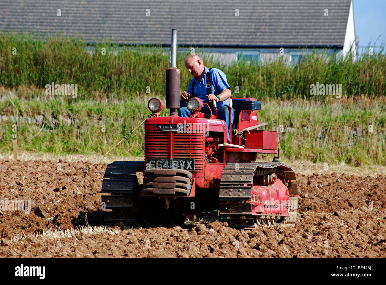 ein Bauer, der pflügt ein Feld mit einem alten Stil Traktor, Cornwall, uk Stockfoto