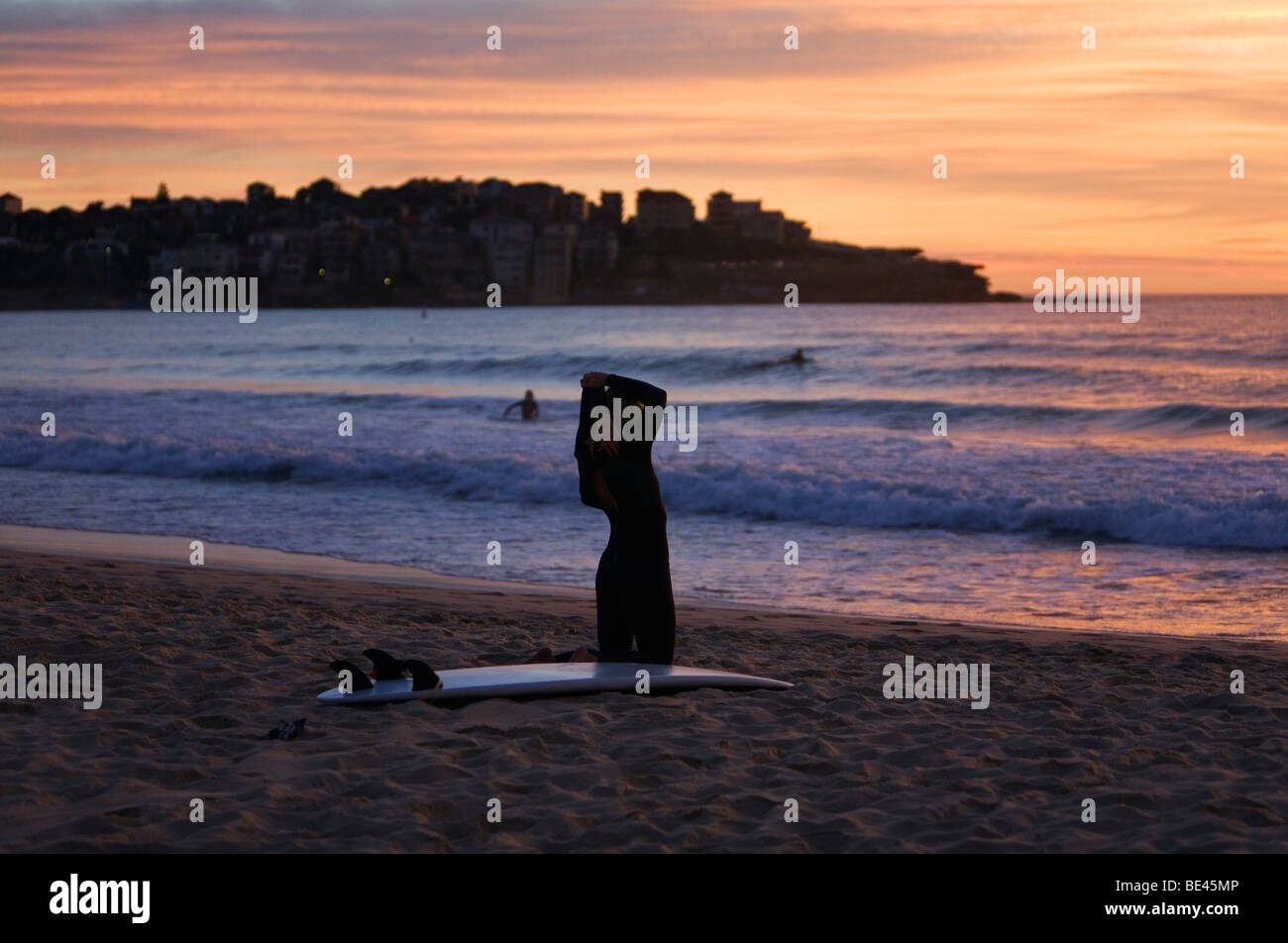 Surfer, stretching, bevor eine Morgendämmerung Surfen am Bondi Beach. Sydney, New South Wales, Australien Stockfoto