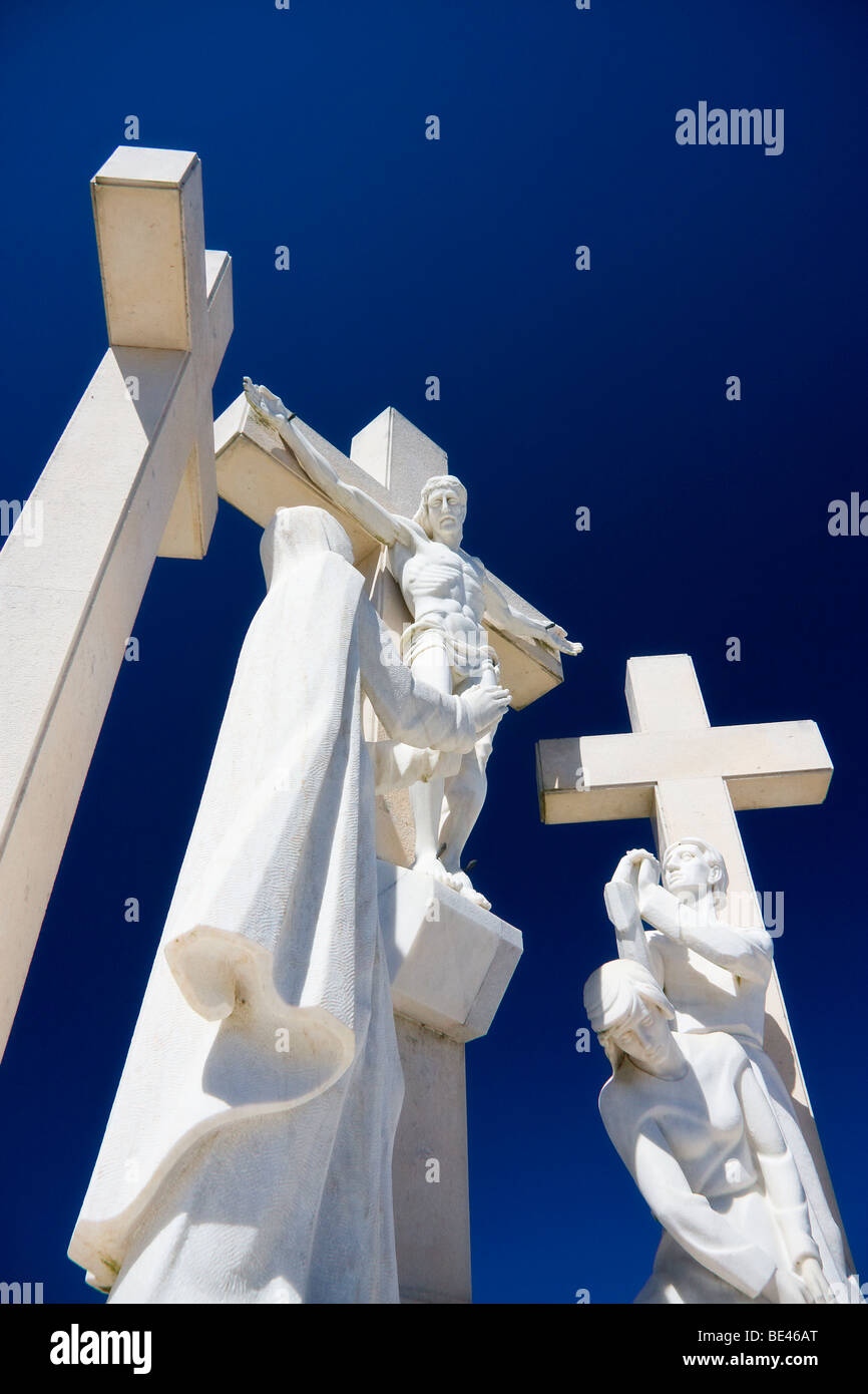 Weiße Marmor-Statuen von Jesus Christus am Kreuz, umgeben von der Jungfrau Maria und zwei leeren Kreuze in Fatima, Portugal. Stockfoto