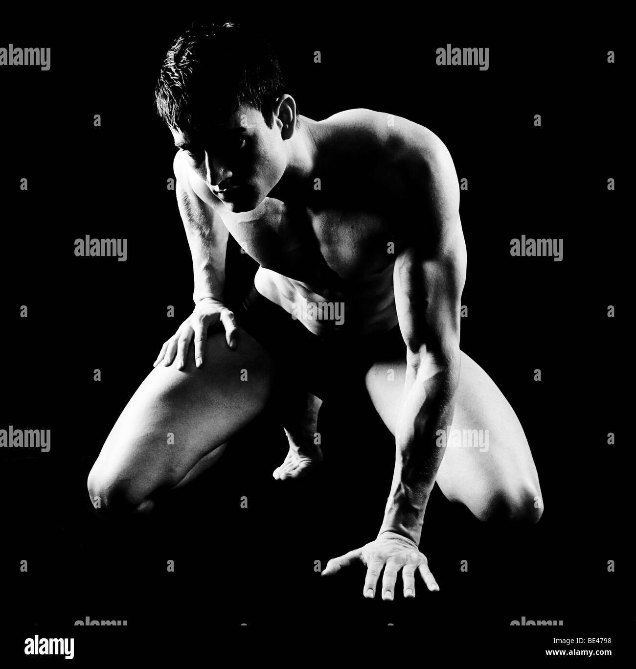 Junger Mann, topless Torsos, kniend, schwarz / weiß, teilweise nackt Stockfotografie Foto Foto