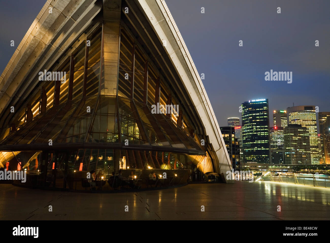 Das Sydney Opera House in der Nacht mit Skyline der Stadt über. Sydney, New South Wales, Australien Stockfoto
