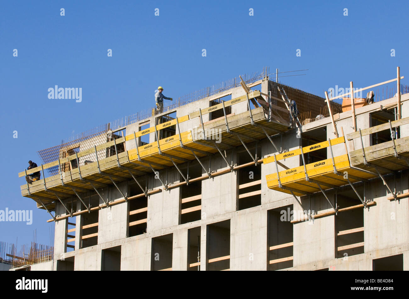 Bauarbeiter, die hoch oben auf einer Strab-Shell, Betonstahl, die an der Spitze des Gebäudes ausgesetzt Stockfoto