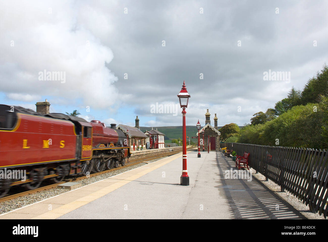 Dampfzug mit Geschwindigkeit durch Garsdale Bahnhof an der Bahnstrecke Settle-Carlisle geleitet, Yorkshire Dales England UK Stockfoto