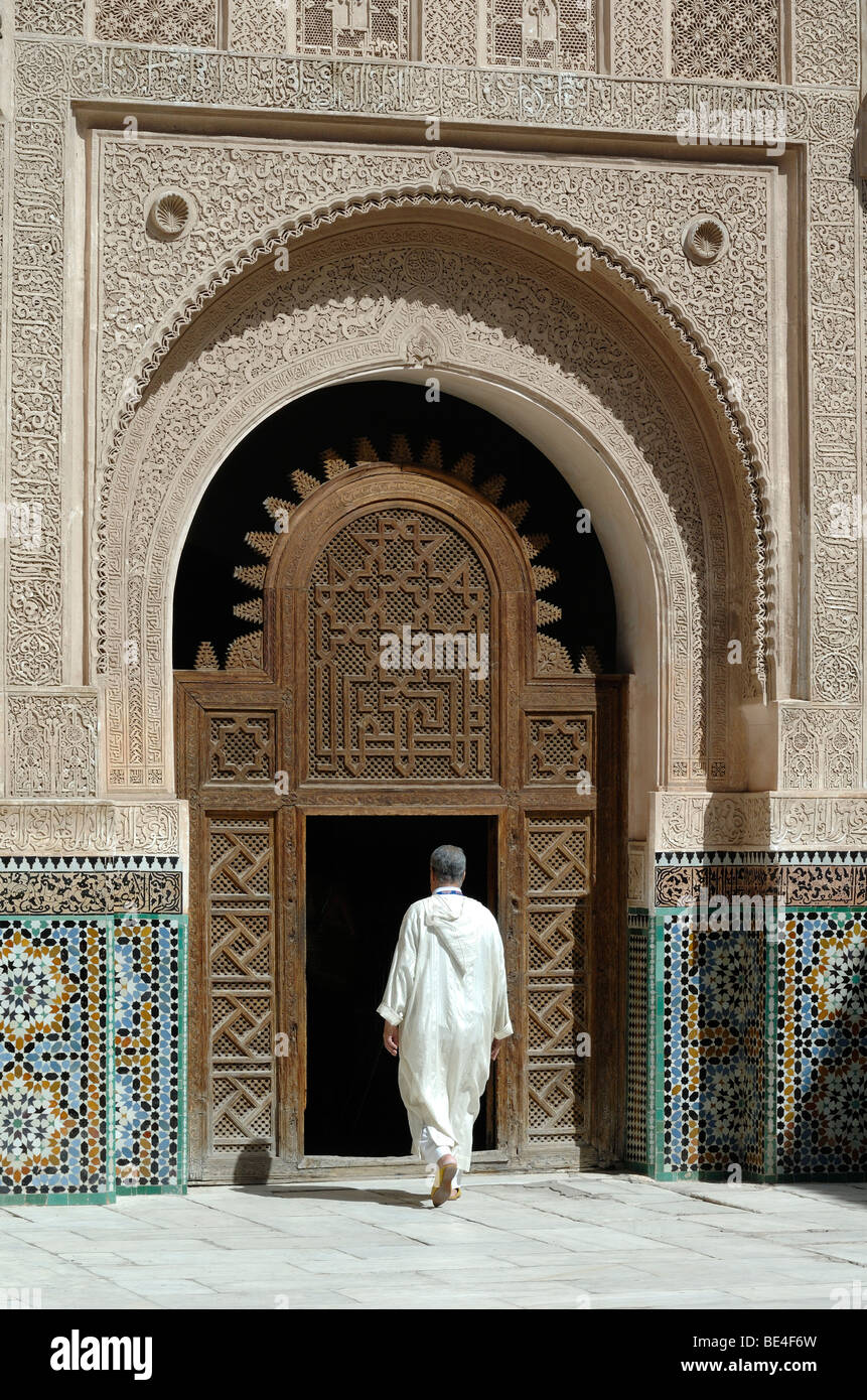 Haupteingang und marokkanischen Mann am Ali Ben Youssef Medersa, Medresse oder islamische Coranic Schule, Marrakesch, Marokko Stockfoto