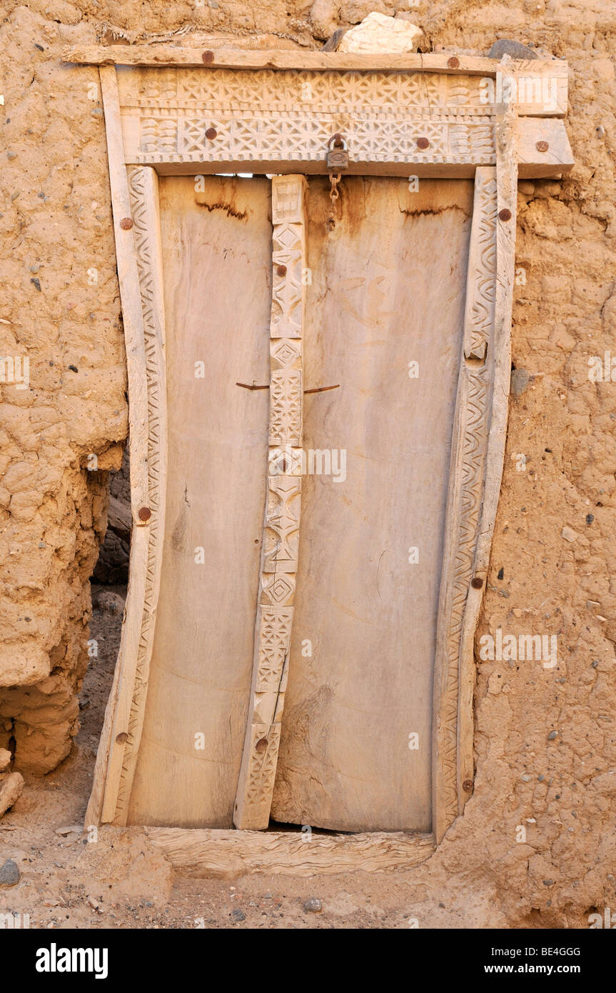 Historic geschnitzte Tür, Adobe-Wand, alte Stadt Sinaw, Naher Osten, Arabien, Sultanat Oman, Sharqiya Region Stockfoto