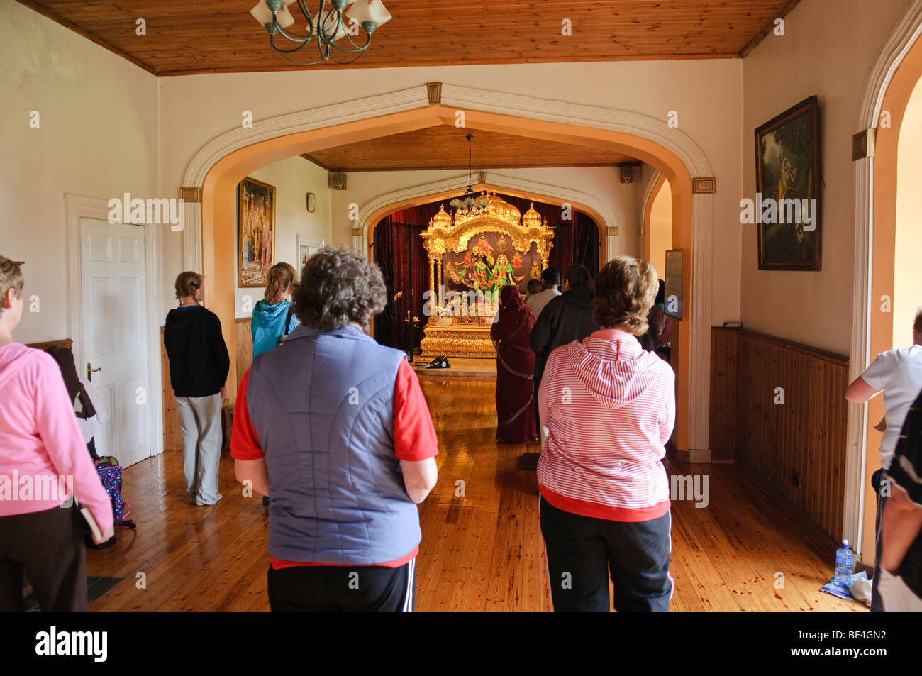 Anhänger-Tanz und Gesang an einem Altar in einem Hare-Krishna-Tempel-Raum Stockfoto