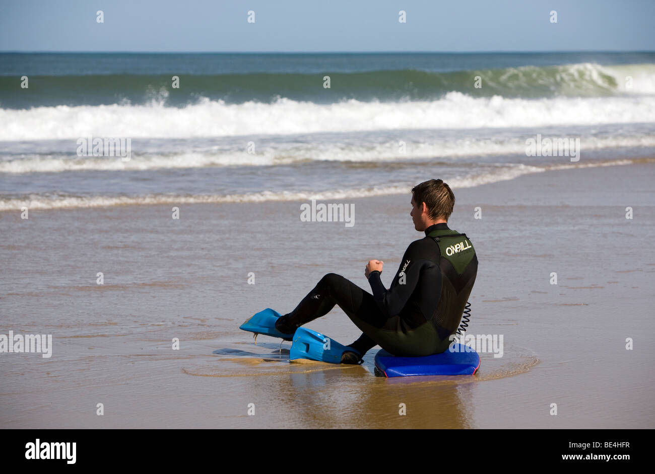 Eine Körper-Board-Surfer in einen Neoprenanzug sitzt am Strand von Lacanau-Ocean entlang der Atlantikküste Süd Westen von Frankreich Stockfoto